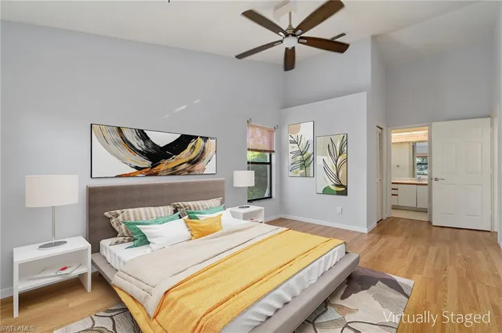 2nd Primary Bedroom Suite, Virtually Staged with soaring vaulted ceilings, ceiling fan, light hardwood / wood-style floors, ensuite bath and large walk-in closet.