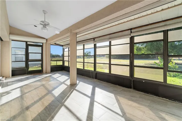 Large Florida screened in sunroom with ceiling fan, vaulted ceilings, and electric storm shutters for convenience.