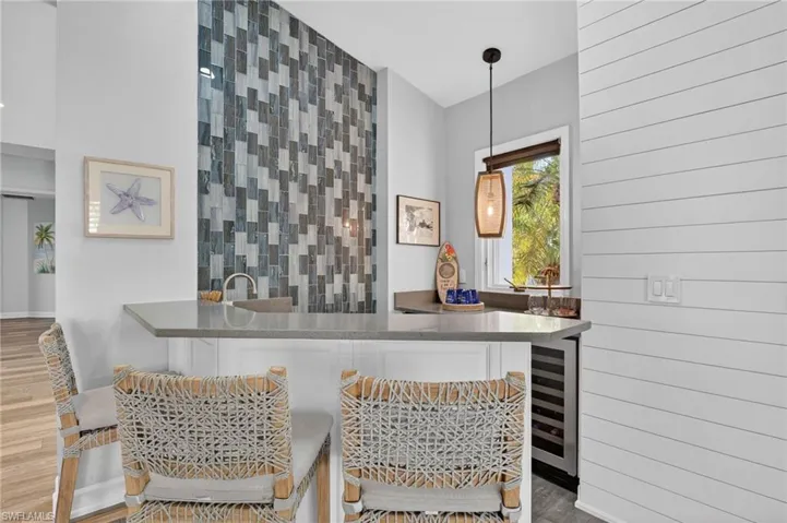 Enjoy happy hour at the bar off the kitchen with seating area and a wine cooler