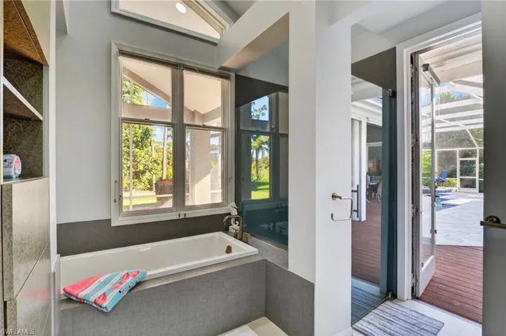 Here's a view of the guest bath with the tub and shower, showing the pool and lanai access