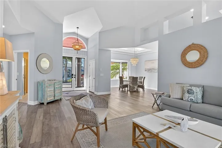 Living room, dining room and entryway highlighting the tall ceilings and light in the home