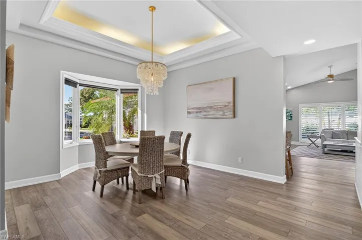 The formal dining room has a tray ceiling with lighting and a beautiful chandelier
