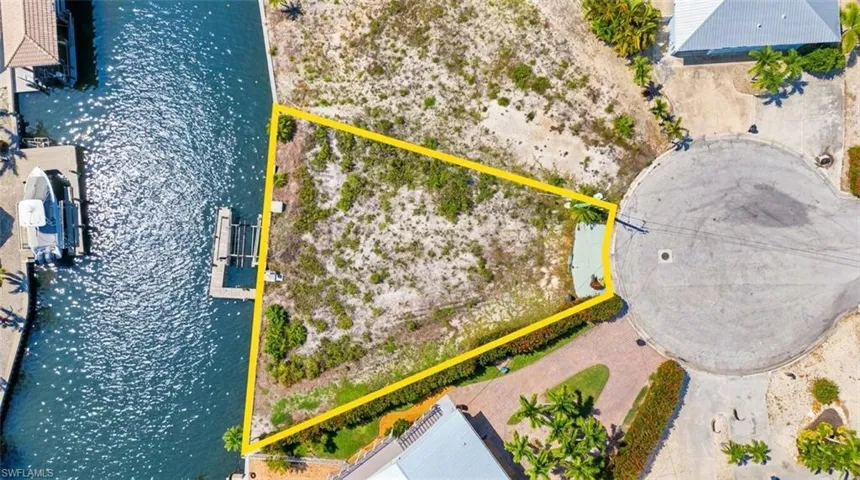 Waterfront lot featuring a private boat lift and direct canal access - Virtually Edited Image