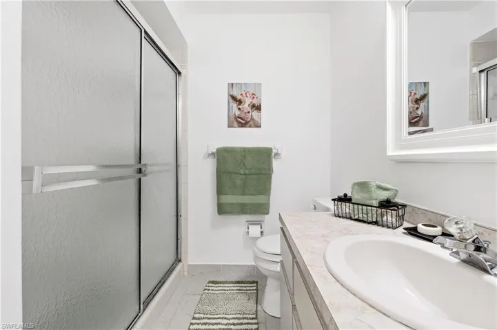 Bathroom featuring a shower stall and vanity