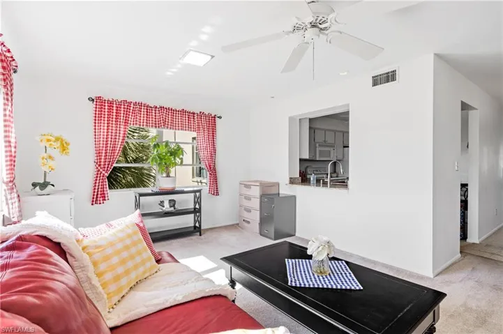 Living room featuring light colored carpet and ceiling fan