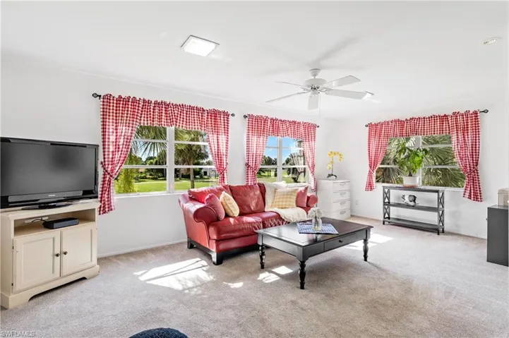 Living room with light carpet and ceiling fan