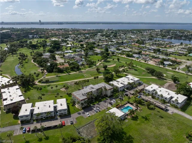 Aerial view of residential area featuring a large body of water and a local golf course