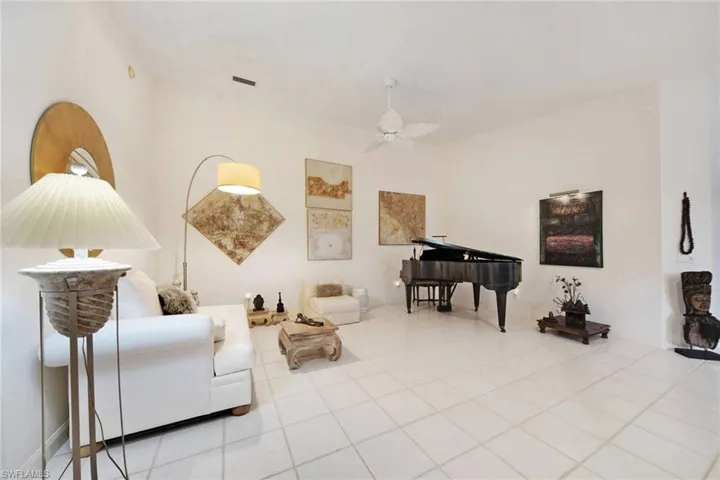 Living area featuring ceiling fan and light tile patterned flooring