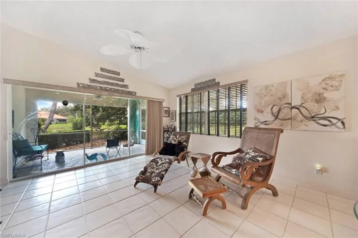 Sitting room with light tile patterned floors, plenty of natural light, lofted ceiling, and ceiling fan
