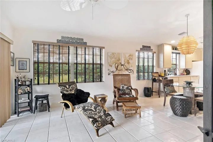 Living area featuring ceiling fan, light tile patterned floors, and sink