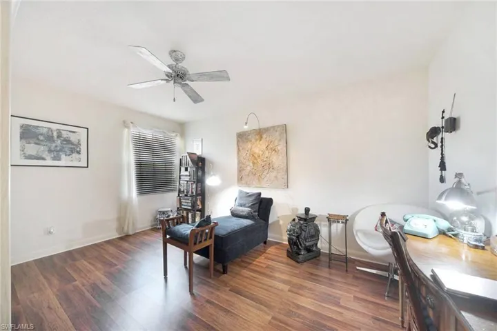 Sitting room featuring ceiling fan and dark wood-type flooring