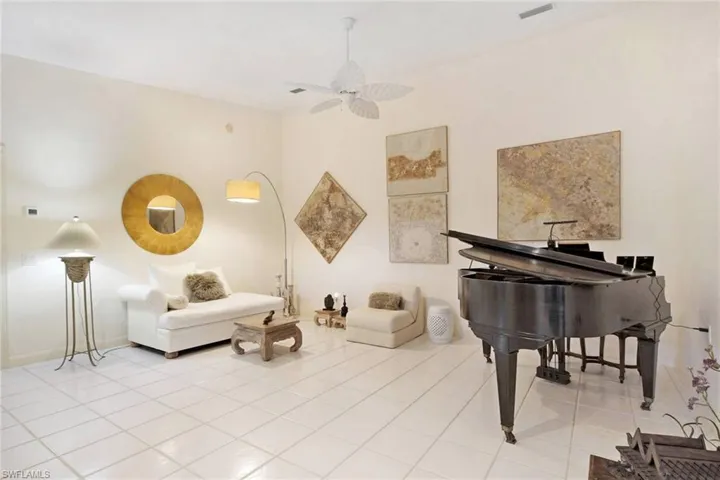 Living area with light tile patterned floors and ceiling fan