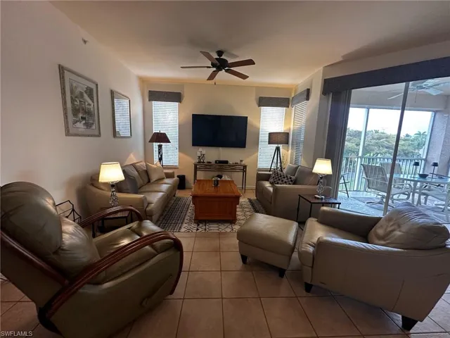 Living room featuring plenty of natural light, ceiling fan, and light tile patterned floors