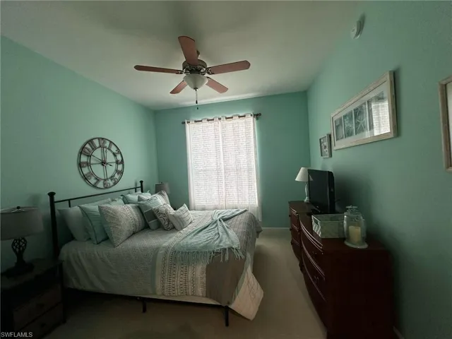 Bedroom featuring a ceiling fan and carpet