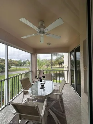 Sunroom with plenty of natural light, a ceiling fan, and a water view
