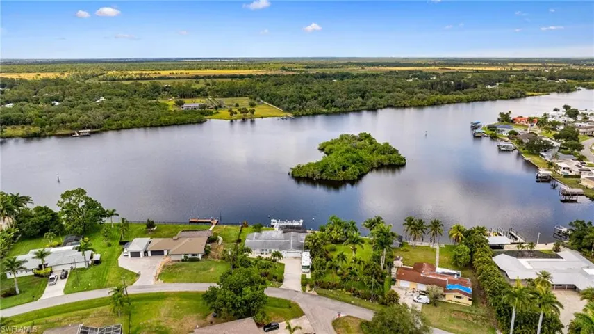 Aerial view of residential area with a large body of water and a heavily wooded area