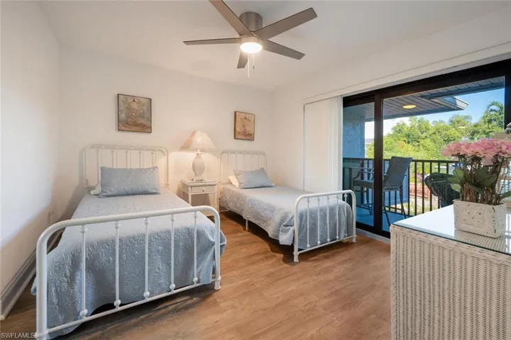 Bedroom featuring ceiling fan, access to exterior, and hardwood / wood-style flooring