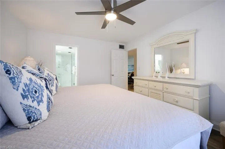Bedroom with connected bathroom, ceiling fan, and hardwood / wood-style flooring