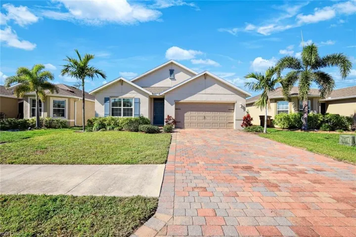 Ranch-style house with a garage and a front lawn