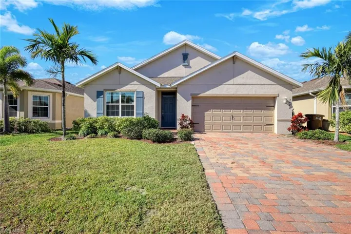 Single story home featuring a garage and a front yard