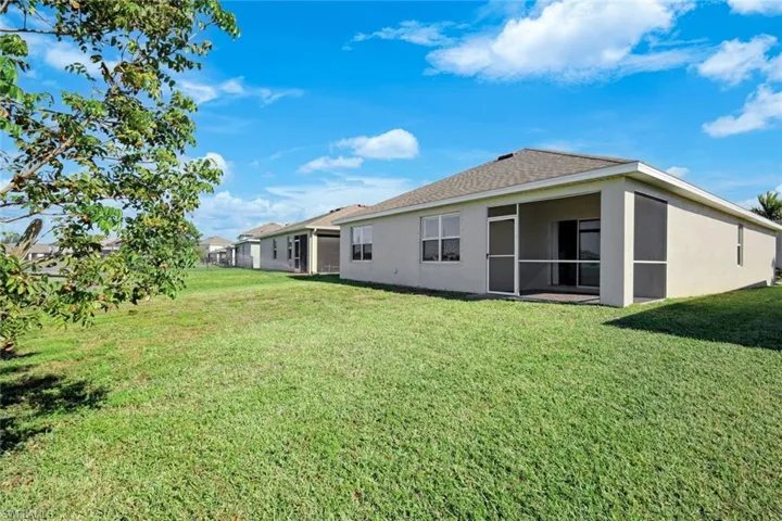 Rear view of property with a yard and a sunroom