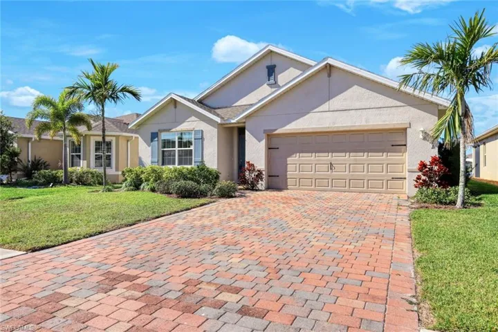 Single story home featuring a garage and a front yard