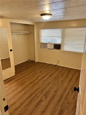 Unfurnished bedroom with dark wood-type flooring and a closet