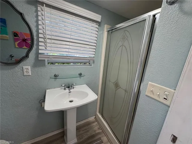 Bathroom with hardwood / wood-style flooring and walk in shower