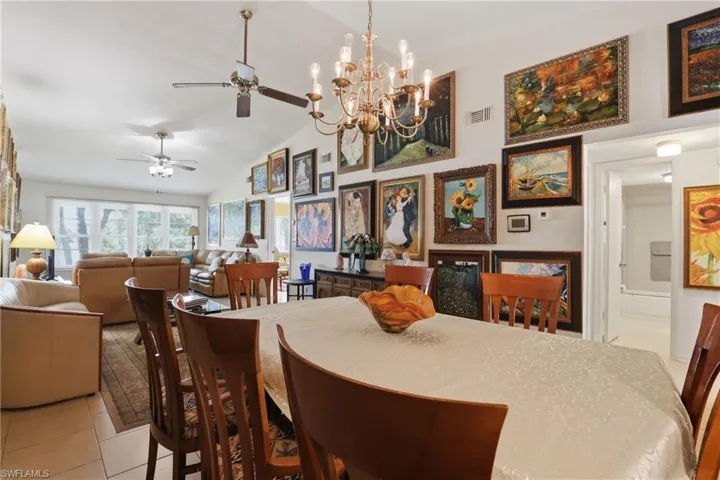 Open-concept dining area with vaulted ceilings and a brass-tone chandelier