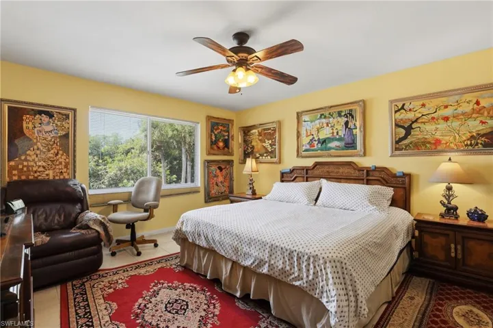Spacious room featuring a multi-pane window, tile flooring, and a ceiling fan with integrated lighting