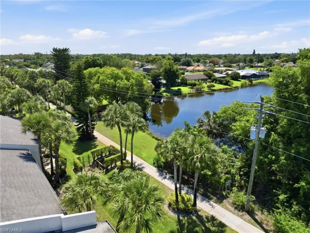 Expansive water frontage with mature trees and lush green landscaping