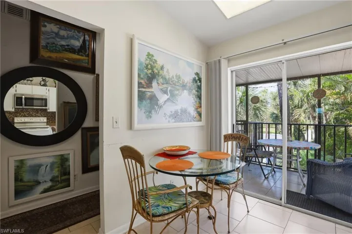 Dining area featuring tile flooring, a glass-top table, and direct access to a screened outdoor space