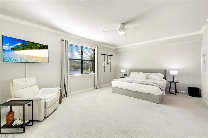 Primary bedroom with crown molding and ceiling fan.