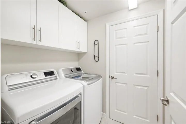 Laundry room with cabinets and updated washer/dryer.
