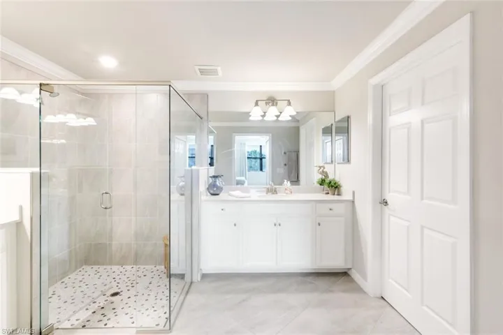 Shower with pebble patterned flooring.