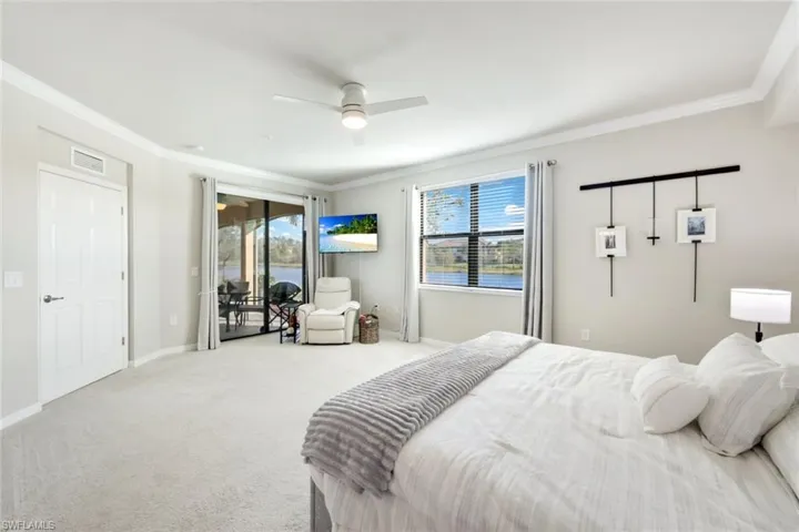 Light, bright primary bedroom with lake view and lanai access.