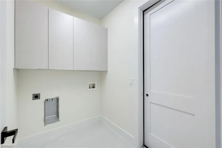 Laundry area featuring dryer and washer hookups and cabinet space.