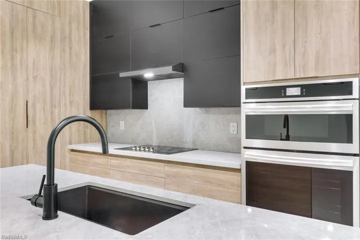 This kitchen is equipped with high-quality appliances, including a wall oven, cooktop, and refrigerator, offering both style and functionality for all your cooking needs.