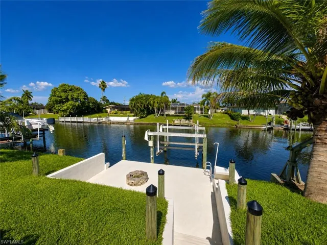 Waterfront property featuring a private boat lift, concrete dock, and direct canal access