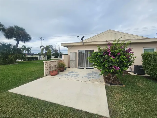 Back of property featuring a yard, stucco siding, and a patio area