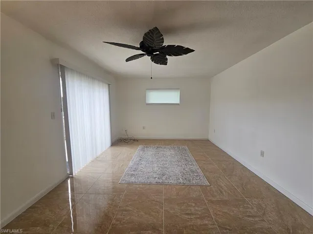 Empty room with a textured ceiling and ceiling fan