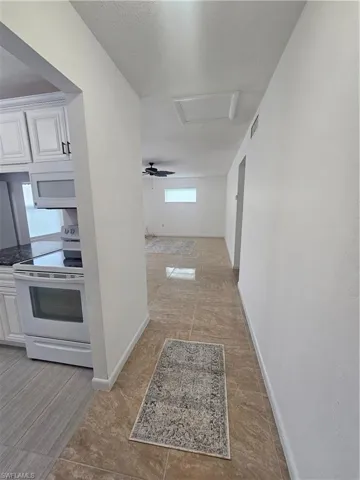 Corridor featuring attic access and a textured ceiling