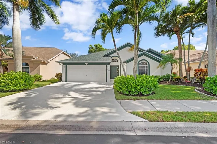 View of front of property with a garage, stucco siding, driveway, and a front yard