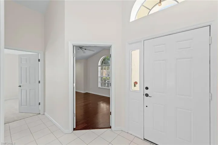 Foyer featuring light tile patterned floors, a towering ceiling, and ceiling fan
