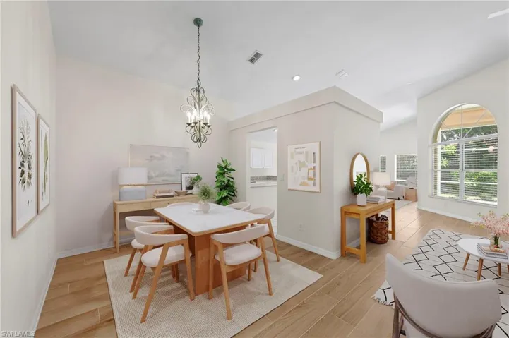 Dining room with light wood-style floors, a chandelier, recessed lighting, and lofted ceiling