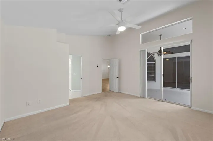 Unfurnished bedroom with light colored carpet, ceiling fan, a towering ceiling, and access to outside