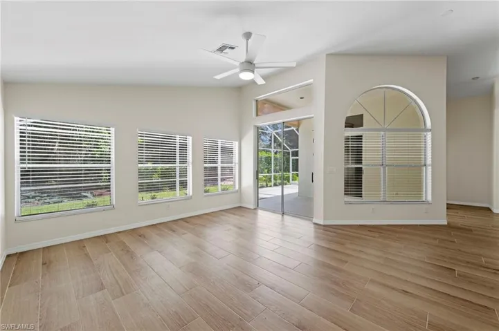 Unfurnished living room featuring lofted ceiling, plenty of natural light, light wood-style floors, and a ceiling fan