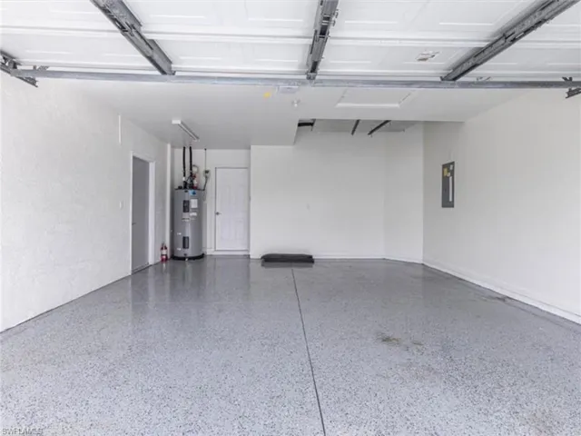 Garage featuring water heater and electric panel