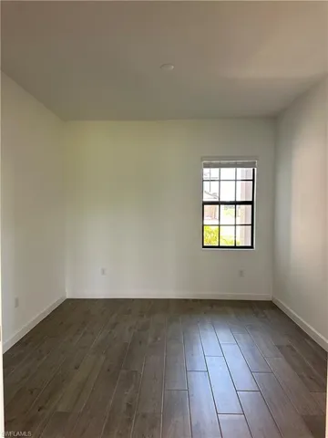Unfurnished room featuring dark hardwood / wood-style floors