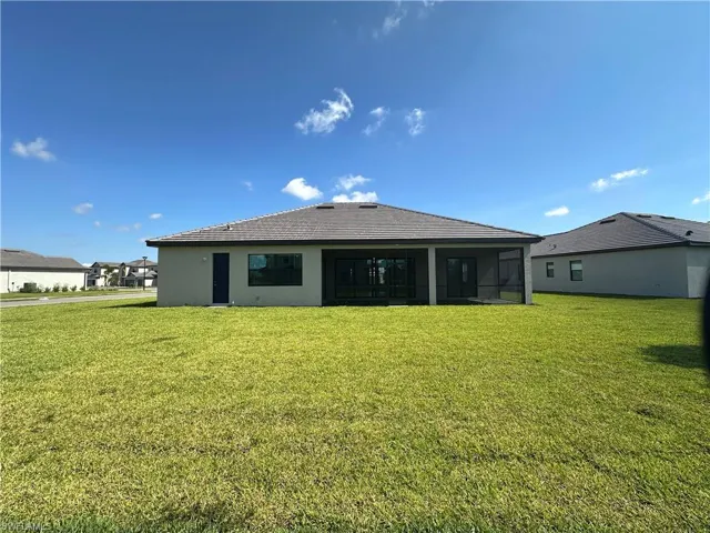 Back of property with a lawn